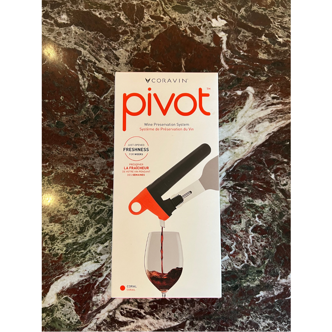The Coravin Pivot in shade Coral shown in its box on a marble table top